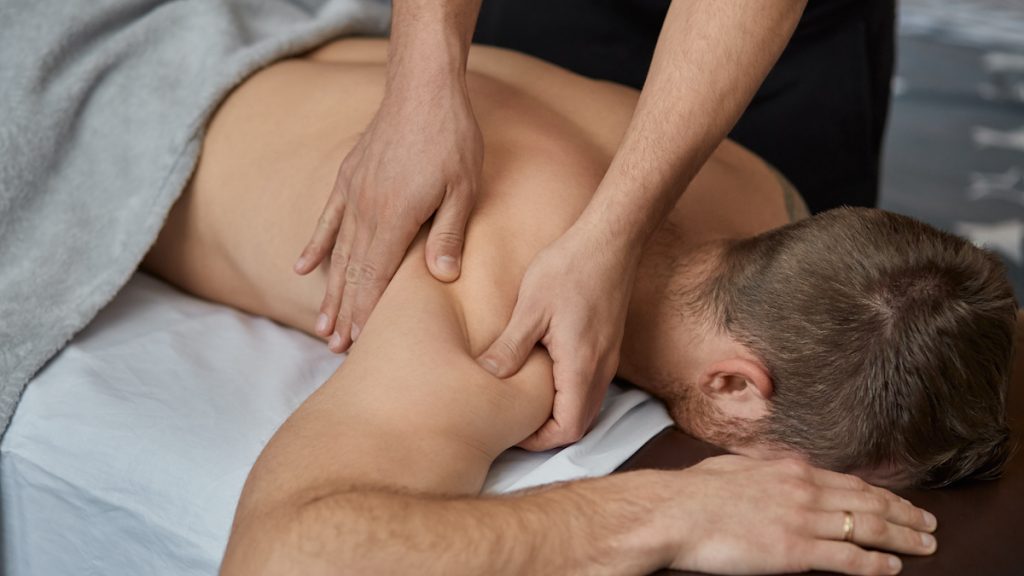 Young man enjoying the benefits of medical massage