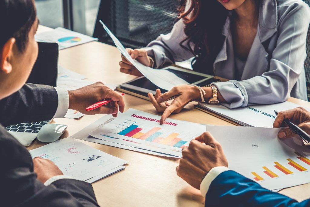 Smart businessman and businesswoman talking discussion in group meeting at office table in a modern office interior. Business collaboration strategic planning and brainstorming of coworkers.