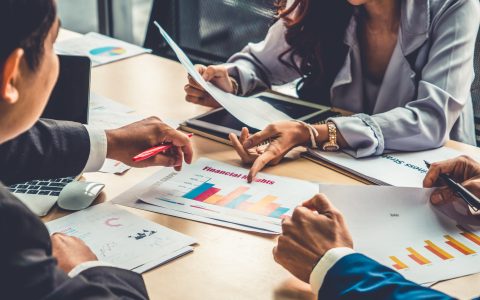 Smart businessman and businesswoman talking discussion in group meeting at office table in a modern office interior. Business collaboration strategic planning and brainstorming of coworkers.